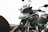 A close-up of a modern motorcycle with a sleek design. The bike features a large windshield, angular headlights, and distinctive branding on the body. Its bodywork includes a combination of metallic and matte finishes.
