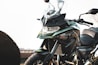 A close-up of a modern motorcycle with a sleek design. The bike features a large windshield, angular headlights, and distinctive branding on the body. Its bodywork includes a combination of metallic and matte finishes.