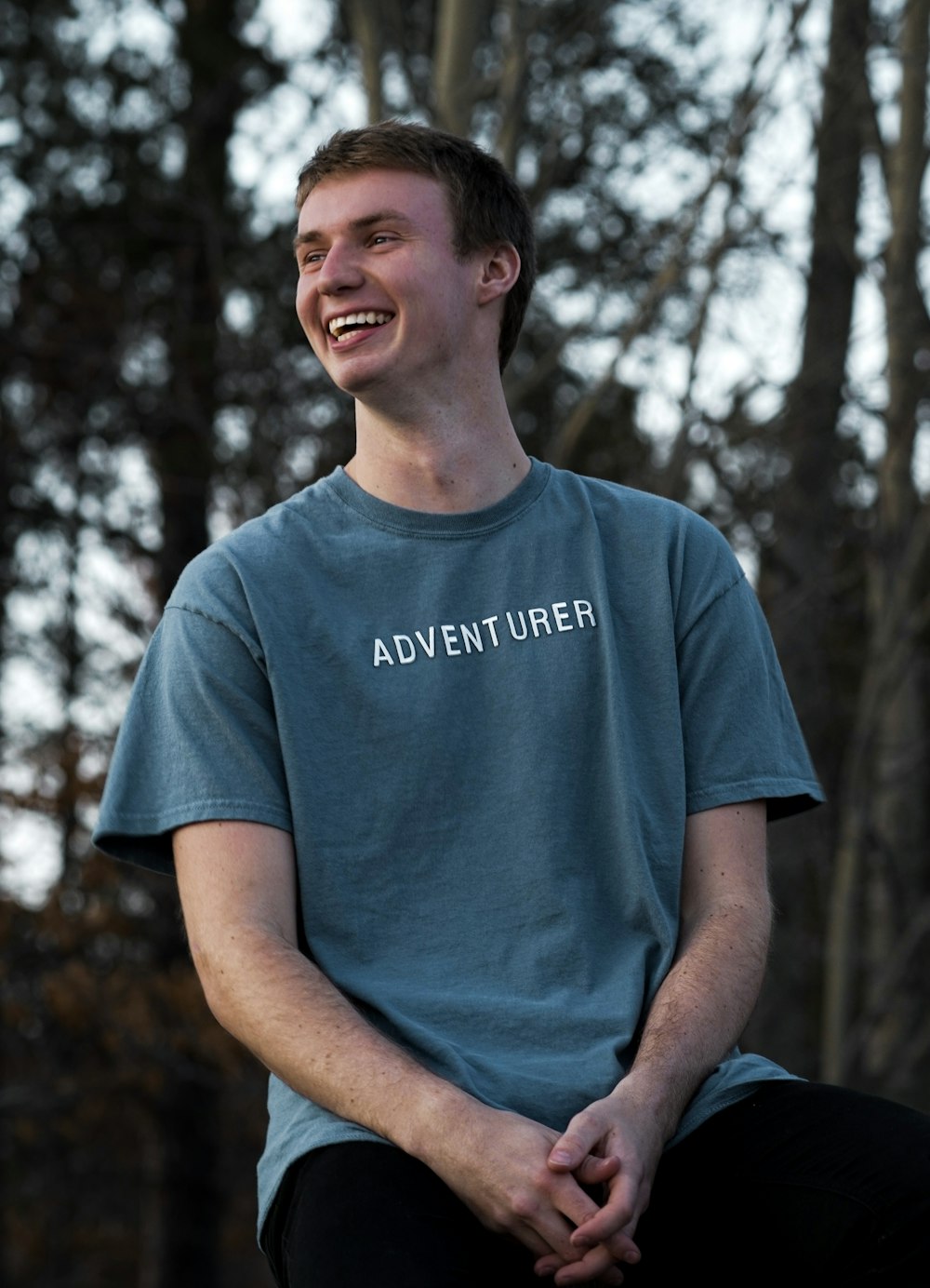 a young man smiles while sitting on a skateboard