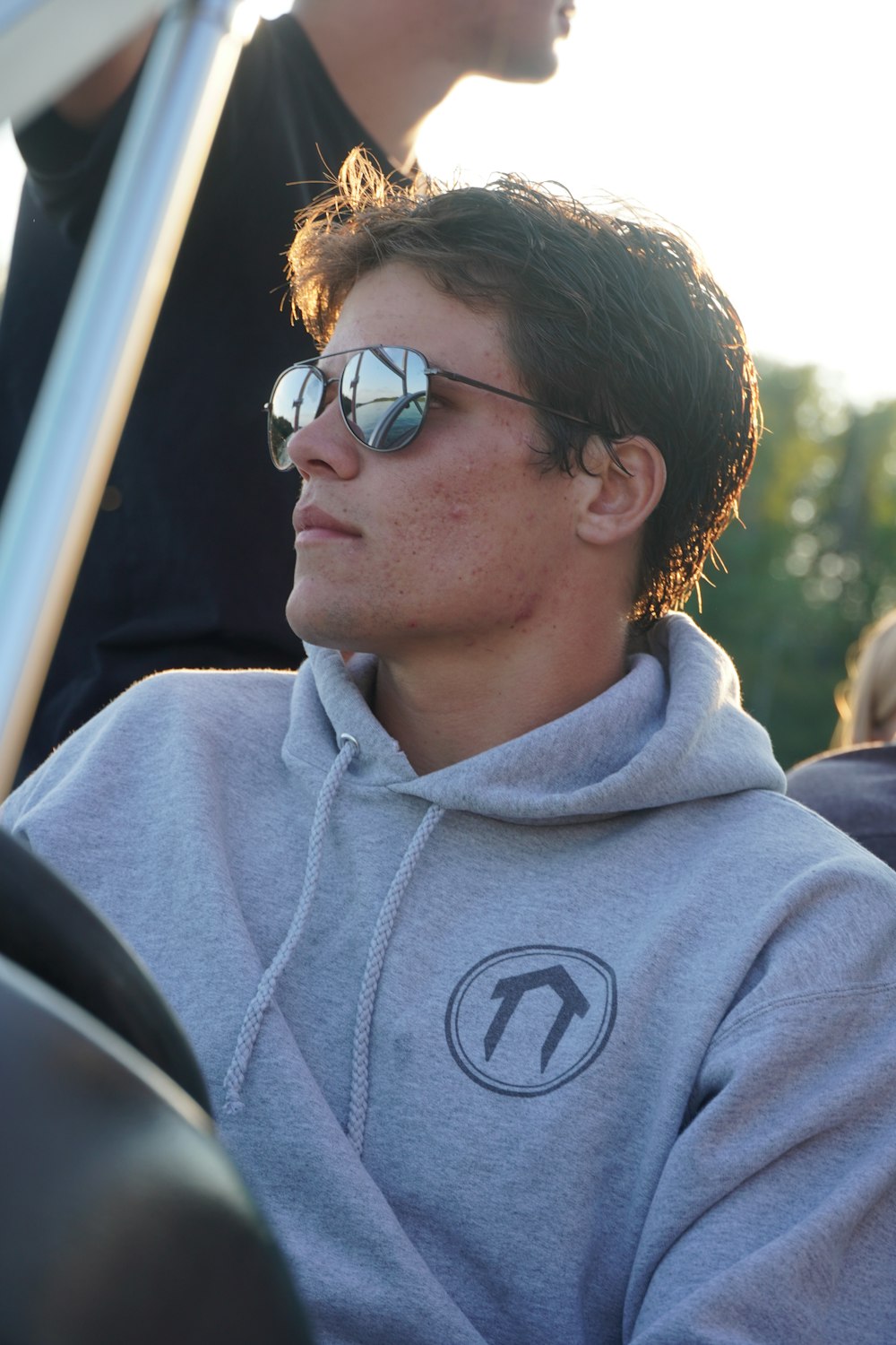 a man in a gray hoodie and sunglasses