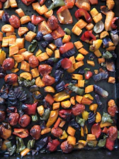 A vibrant skillet filled with colorful roasted vegetables and golden chicken, fresh from the oven.