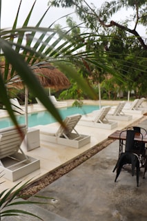 a patio with a table and chairs next to a pool