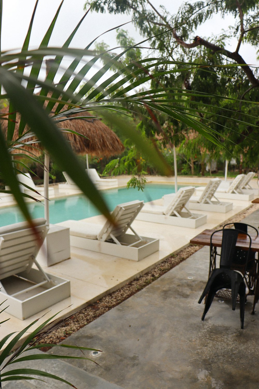 a patio with a table and chairs next to a pool