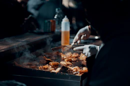 a person is cooking food on a grill