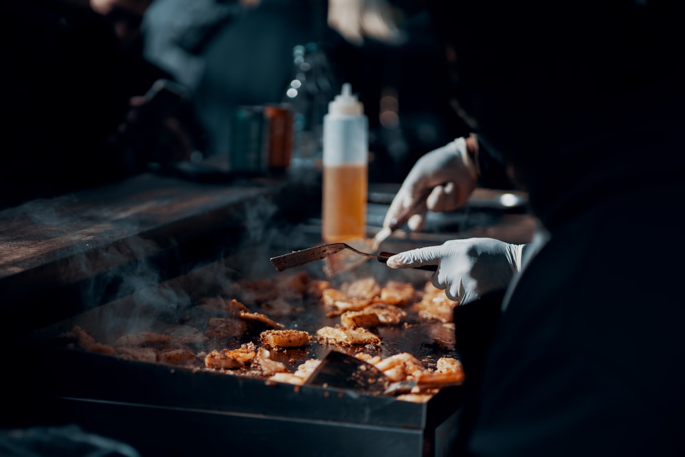 a person is cooking food on a grill