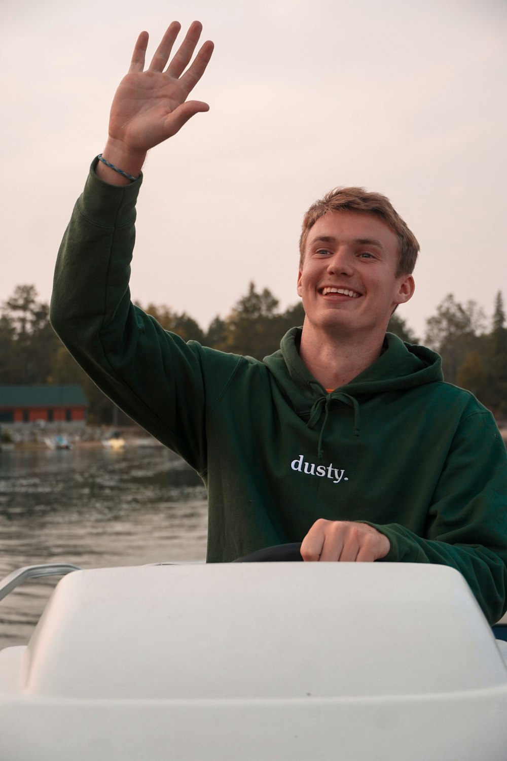 a man waves from a boat in the water