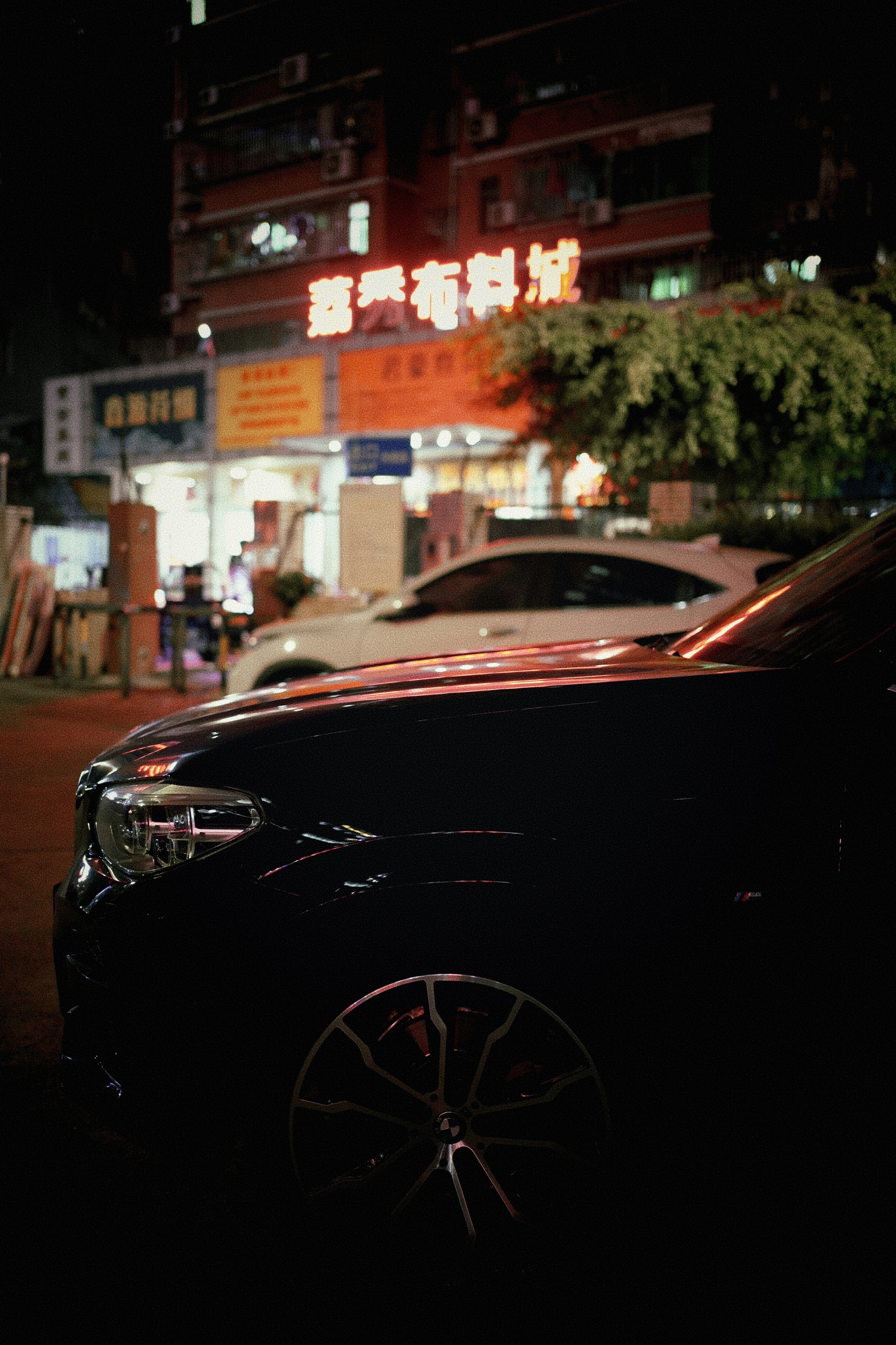a car parked on the side of a street at night