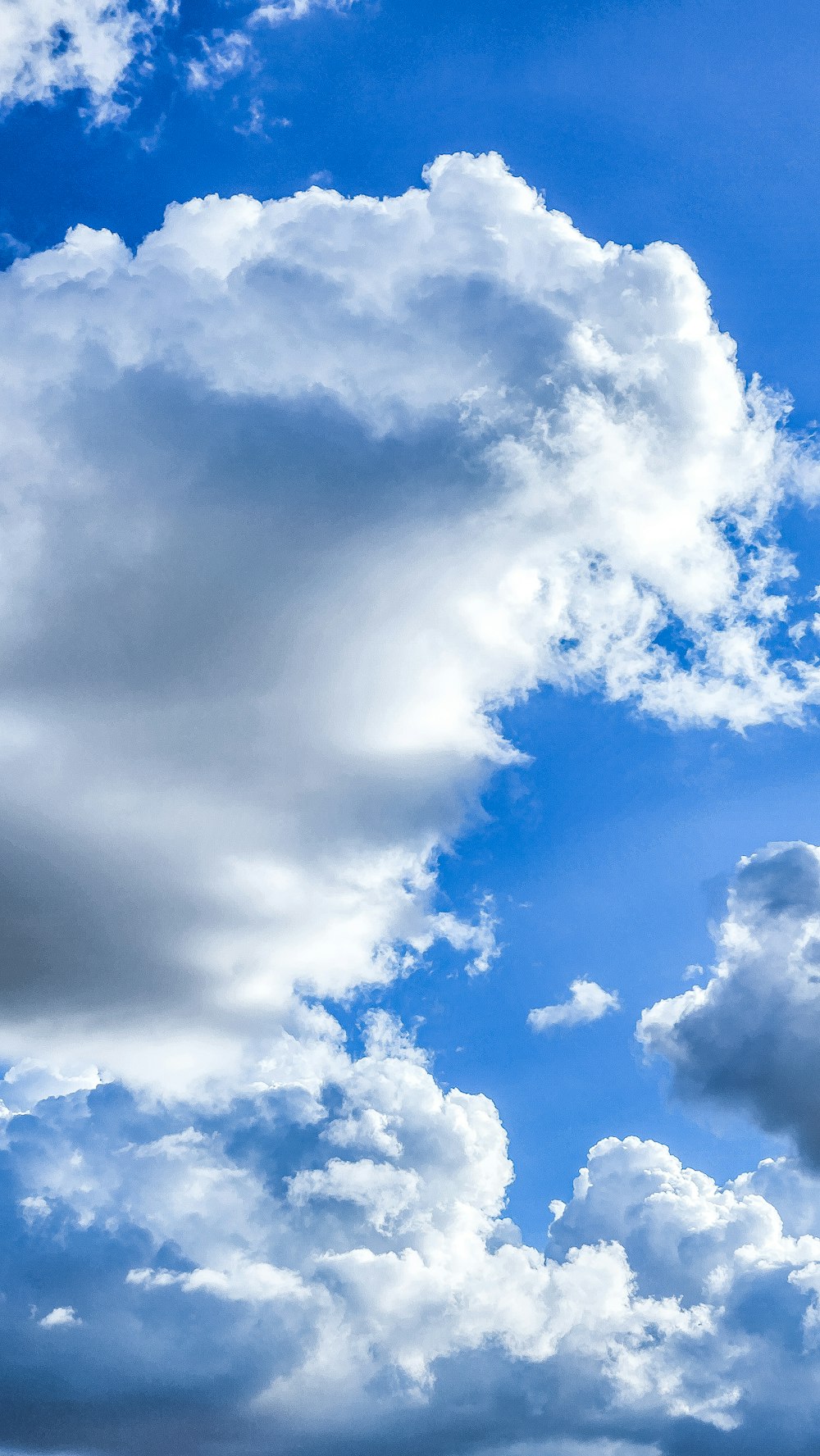 a plane flying through a cloudy blue sky