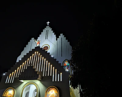 The church facade at sunset with warm lights glowing invitingly.