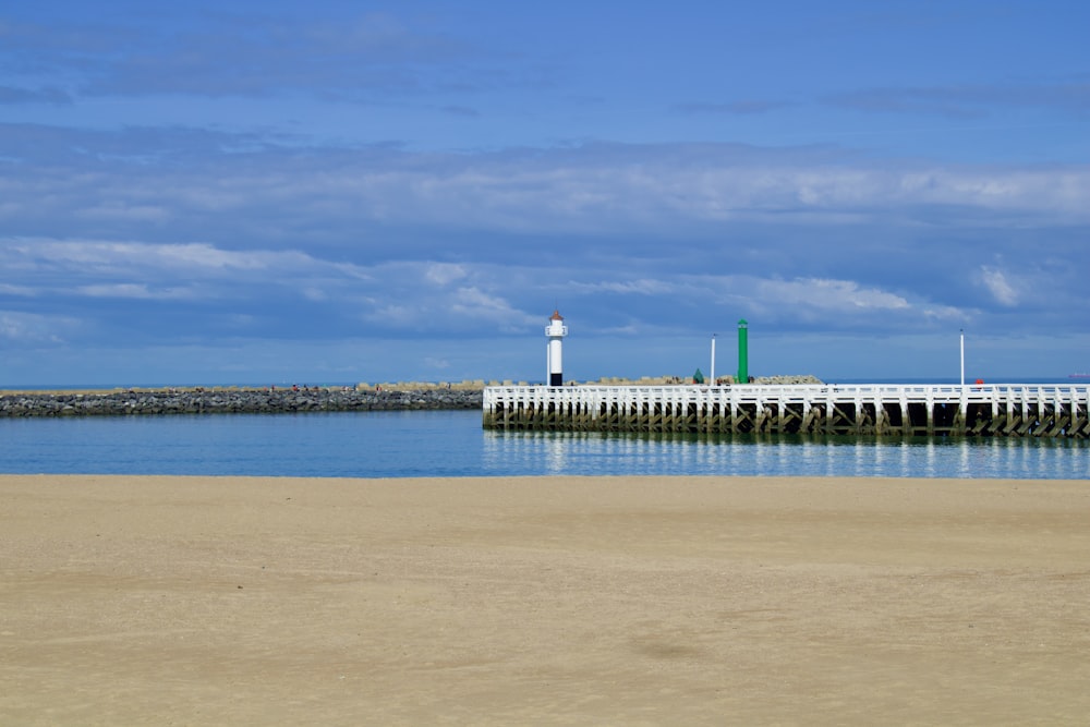 a pier with a light house in the distance