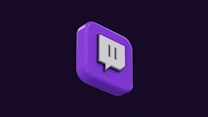 A 3D representation of a purple cube icon with a white speech bubble symbol in the center. The cube is displayed against a dark background, adding a sense of depth and focus on the icon.
