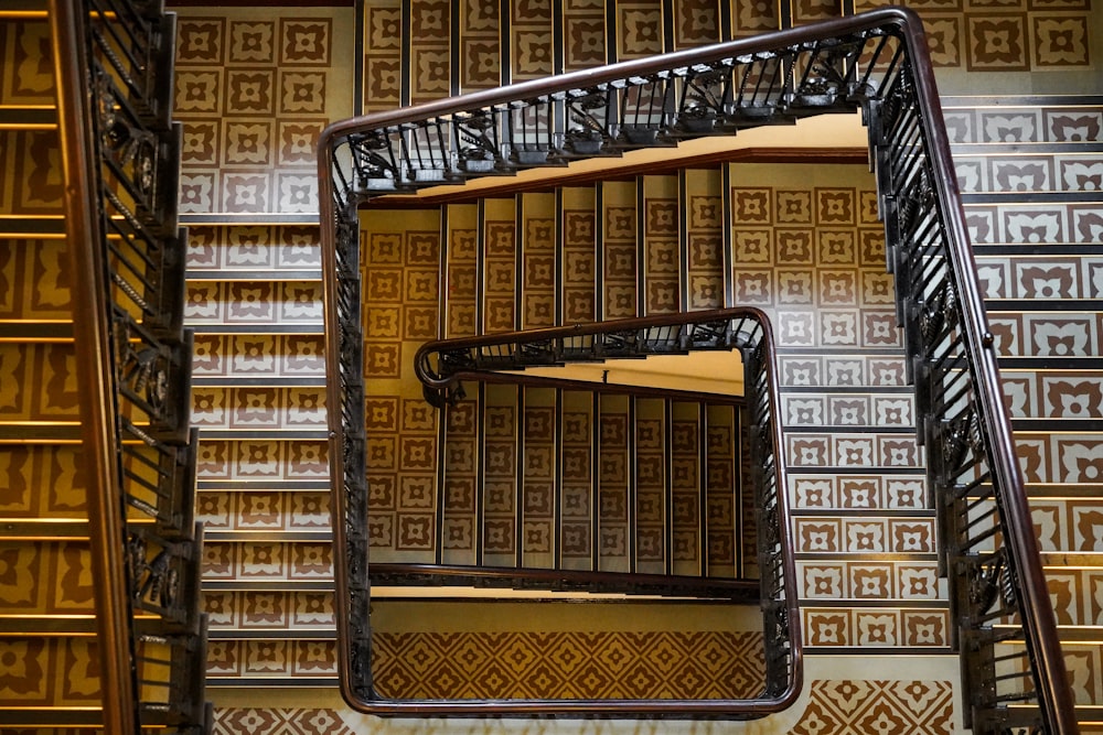 a spiral staircase in a building with decorative wallpaper