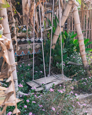 Outdoor swing chair hanging gently amidst lush garden greenery.