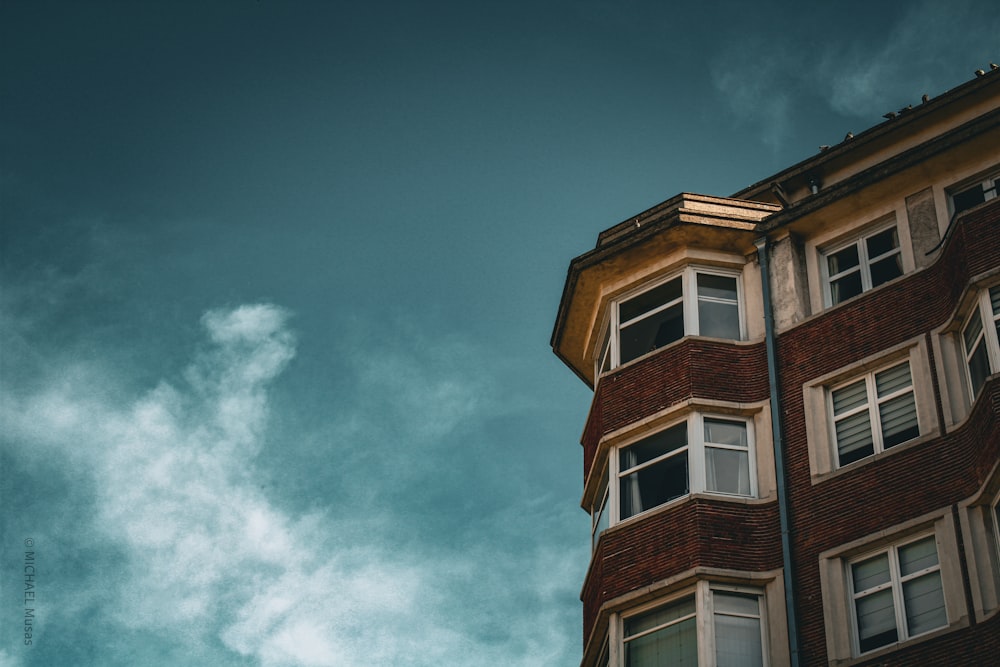 a tall brick building with windows and a sky background