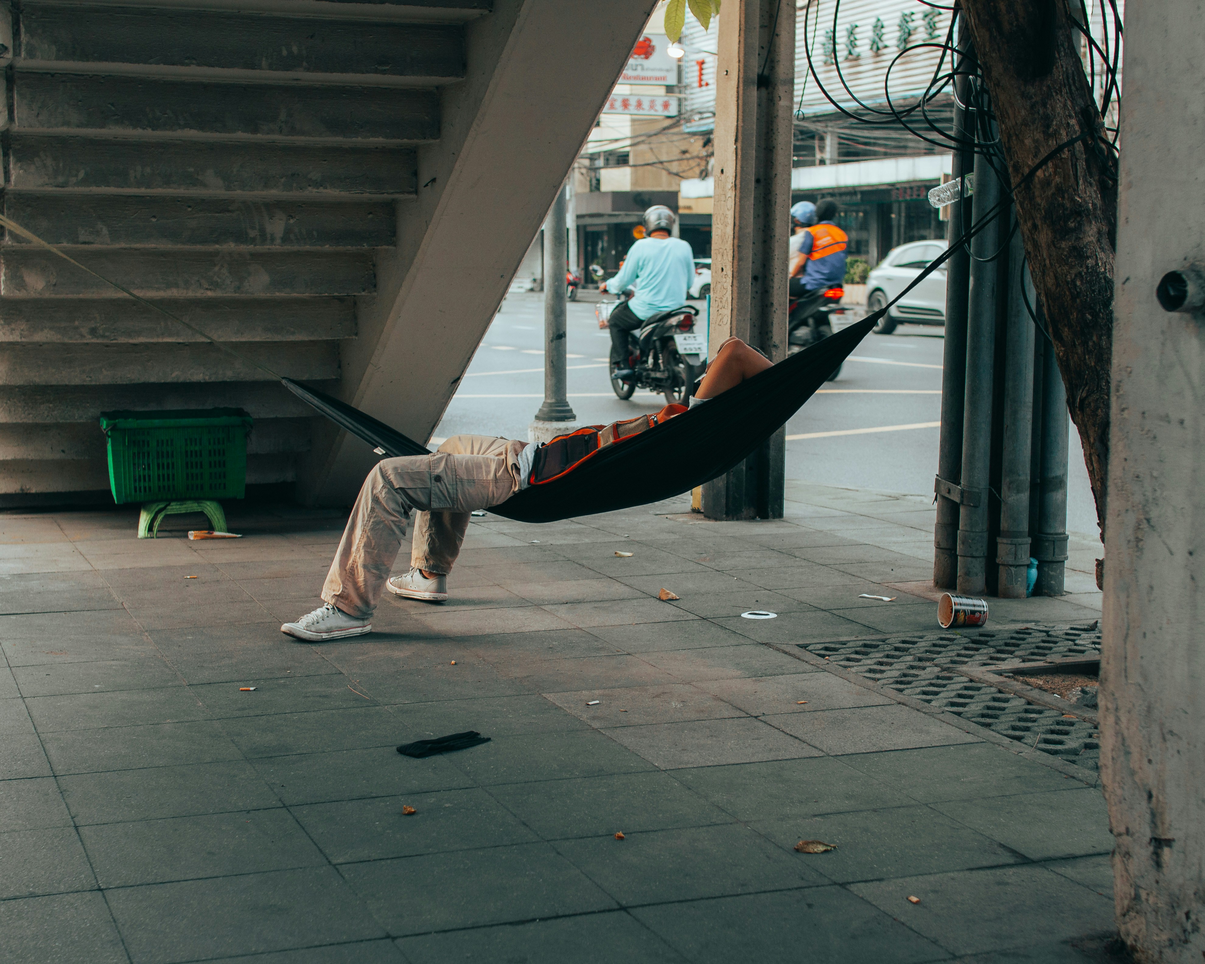 A man in a hammock on a city street