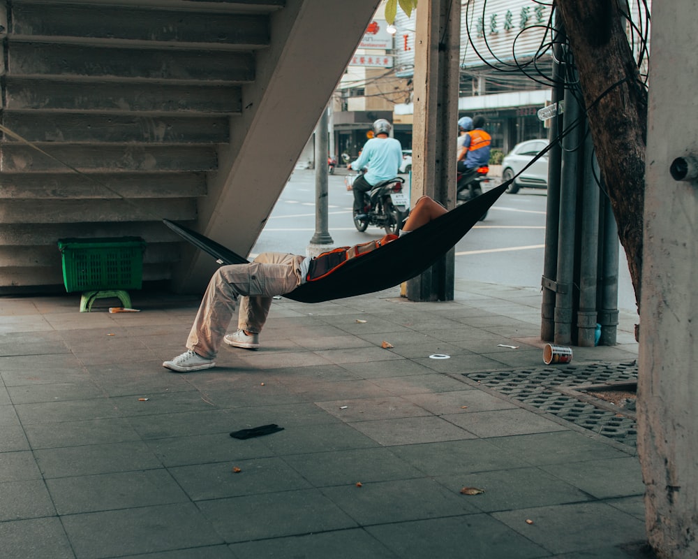 a man in a hammock on a city street