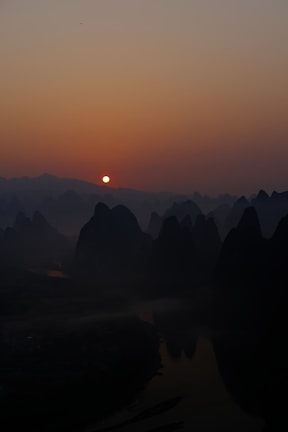 Sunrise casting golden light over Halong Bay's limestone karsts.