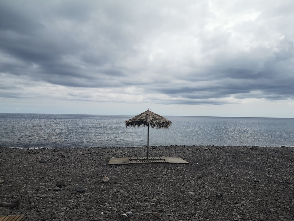 a beach umbrella sitting on top of a sandy beach