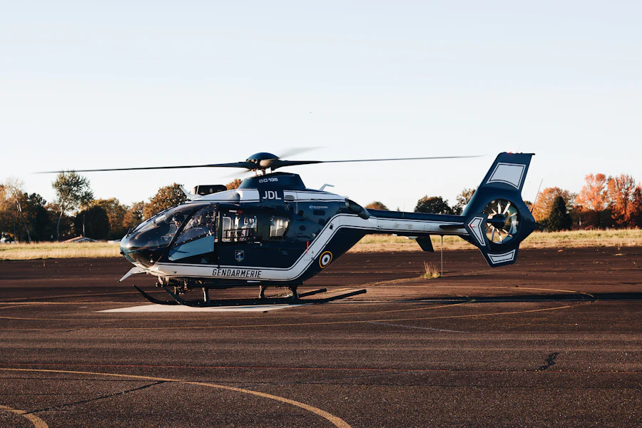 Two light helicopters parked on a grass apron beside a runway