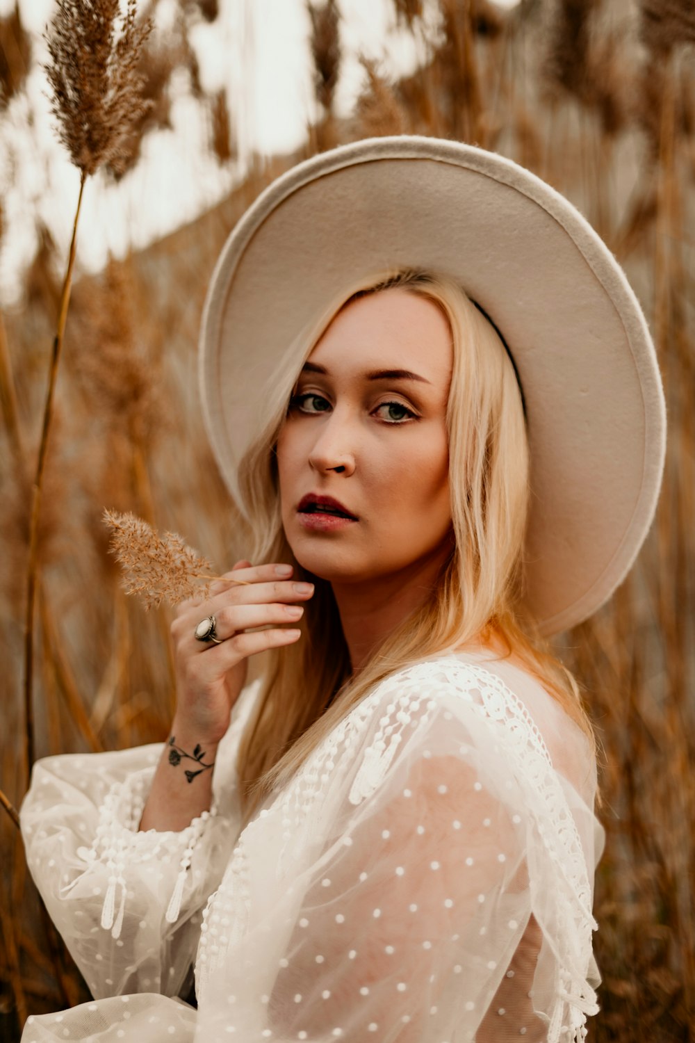 a woman wearing a white hat and a white dress