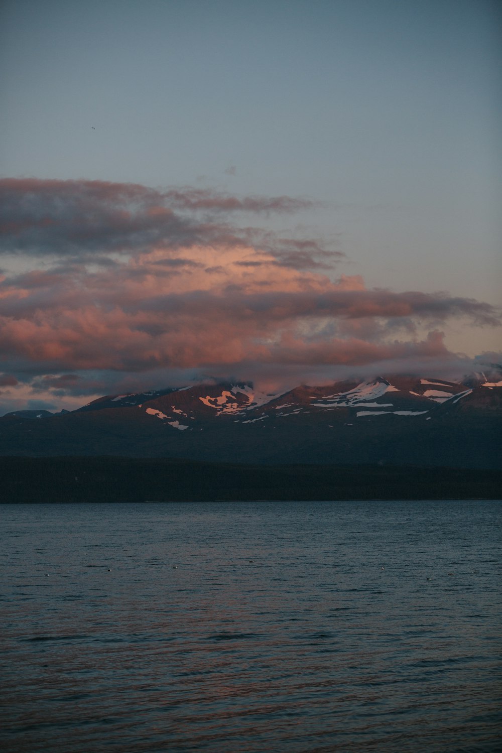 a large body of water with a mountain in the background