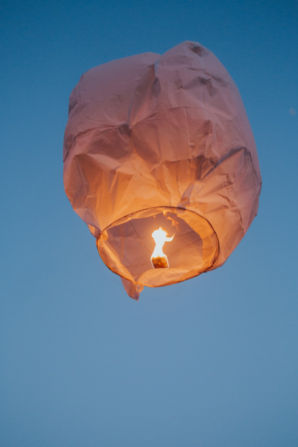 a paper lantern floating in the air with a blue sky in the background