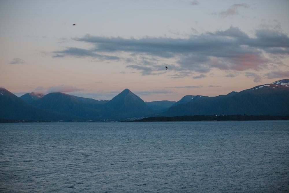 a large body of water with mountains in the background