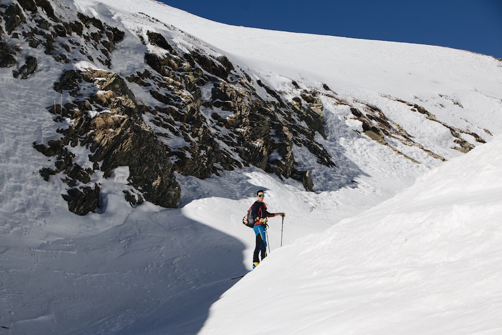 a person walking up the side of a snow covered mountain