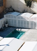 a swimming pool with a white fence surrounding it
