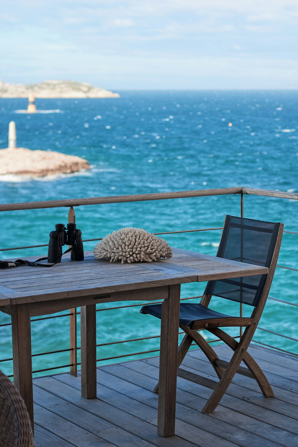a table and chairs on a deck overlooking the ocean