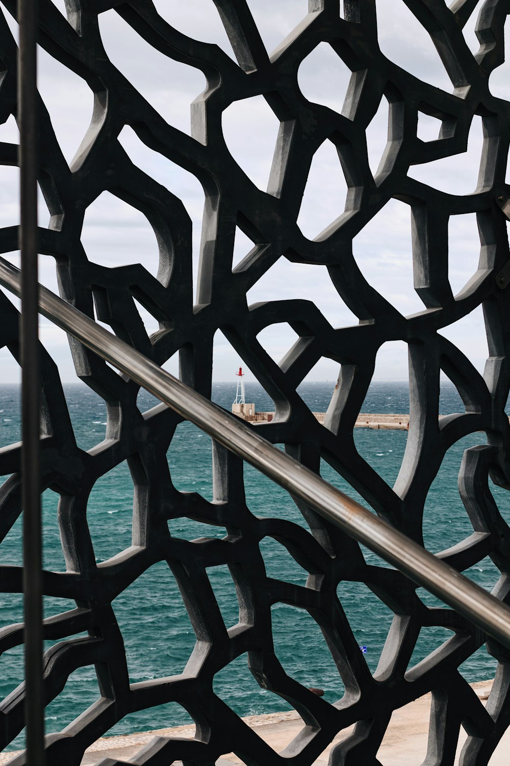 uma vista do oceano através de uma escultura de metal
