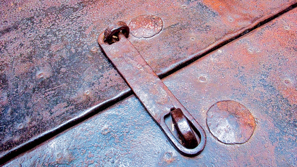 a rusted metal surface with a pair of handles