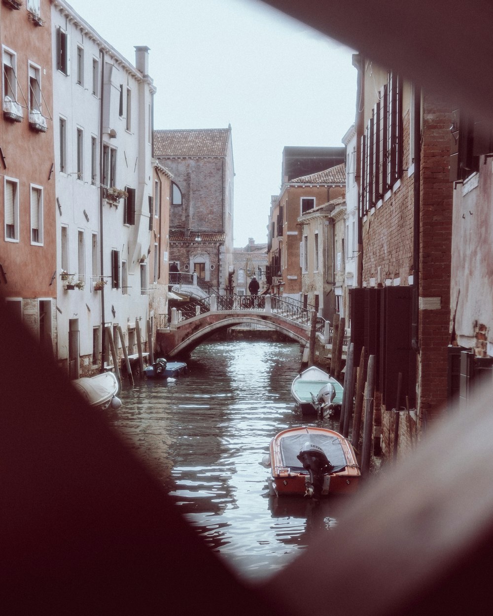 a boat floating down a river next to tall buildings