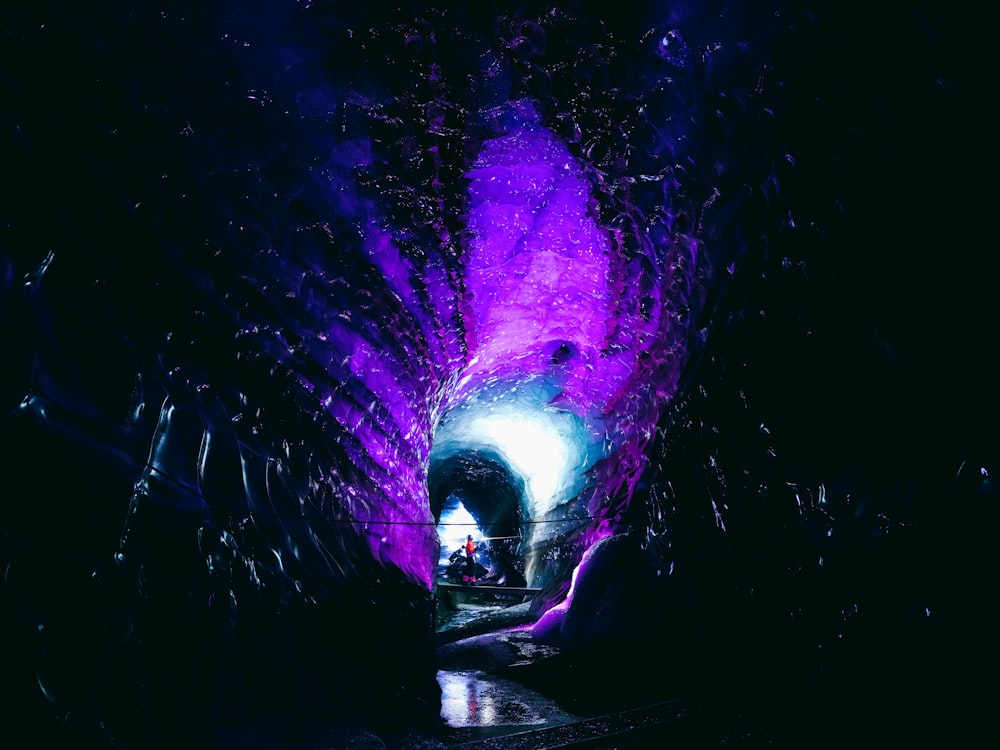 un tunnel sombre avec une lumière violette au bout