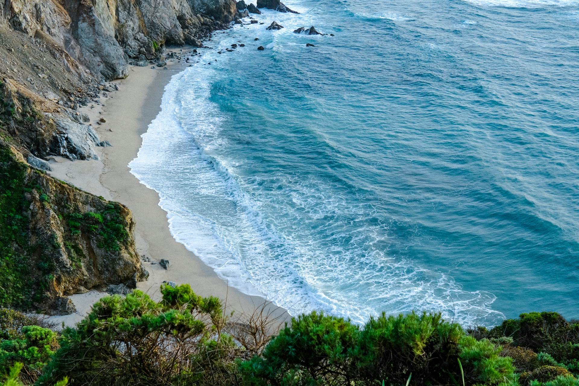 a view of the ocean from the top of a hill