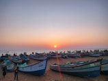Colorful boats floating near the shores of Gopalpur beach at sunset.