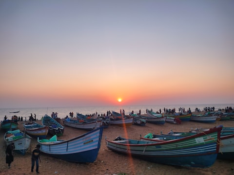 Colorful boats floating near the shores of Gopalpur beach at sunset.