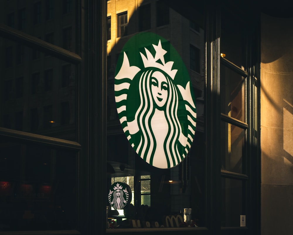 a starbucks sign hanging from the side of a building