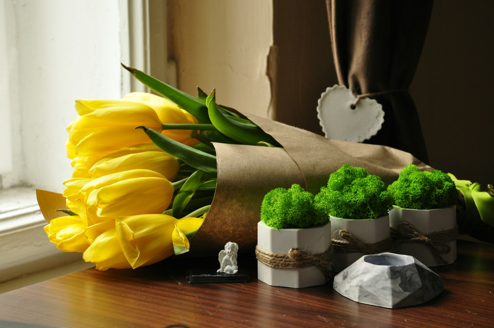 a bouquet of yellow tulips and broccoli on a table