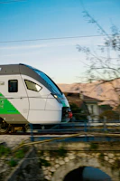A sleek modern train speeding through a scenic countryside landscape