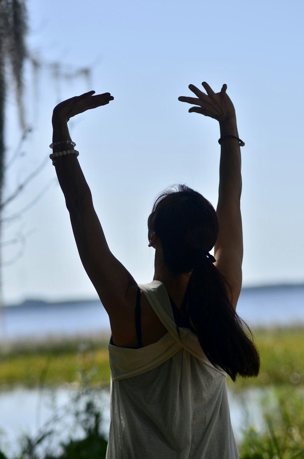 a woman standing in front of a body of water