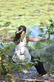 a woman in a white dress is doing yoga