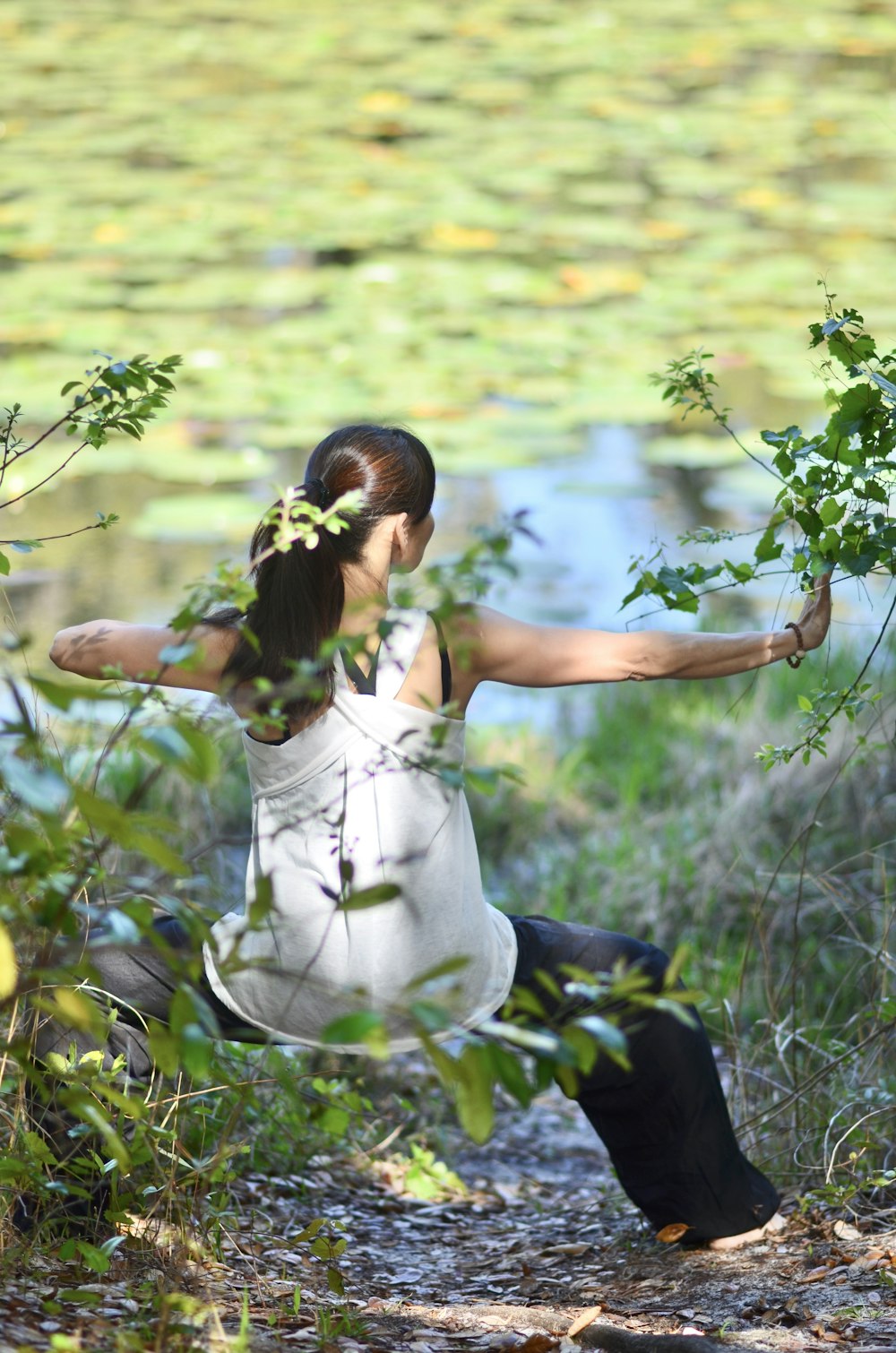 a woman in a white dress is doing yoga