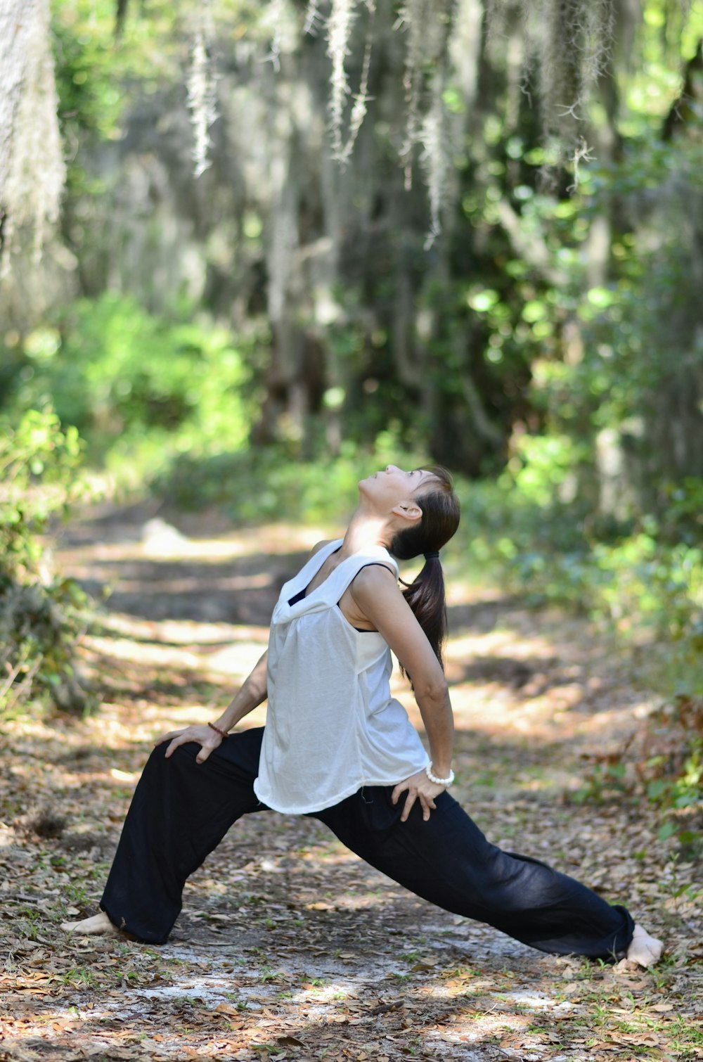 a woman is doing yoga in the woods