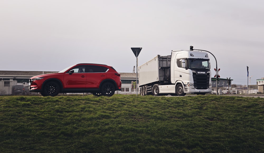 a red car is parked next to a white truck