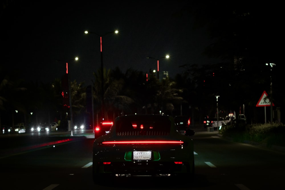 a car driving down a street at night