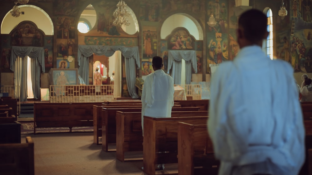 a man standing in front of a pew in a church