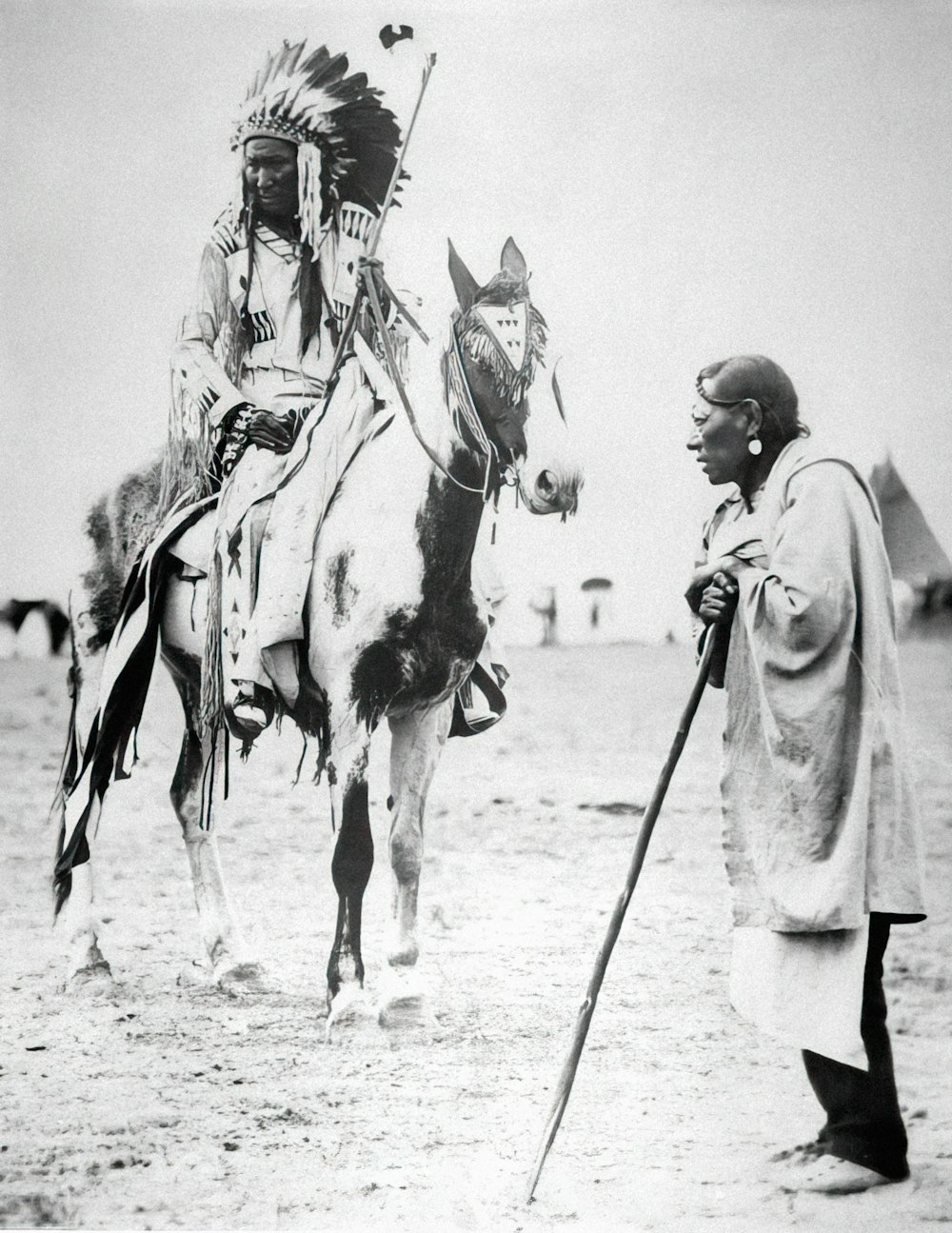 Un homme debout à côté d’un homme sur un cheval
