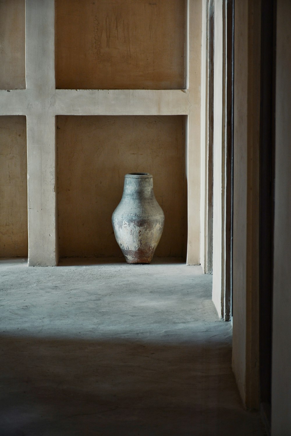 a vase sitting in a corner of a room