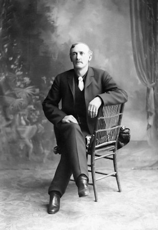 A stylish portrait of Sir Daniel David in a photography studio.